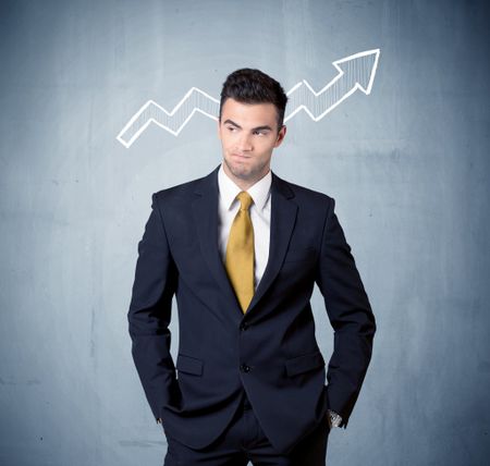 A handsome sales guy standing in front of a blue urban concrete wall with illustration of white graph chart arrows cocncept