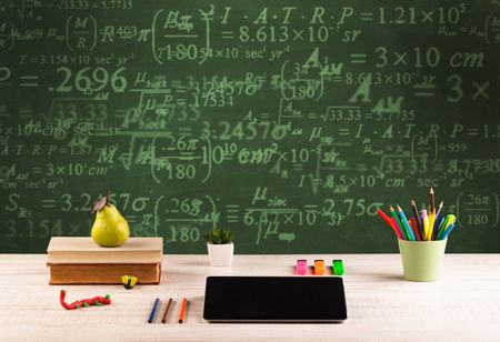 A stuffed school desk with green blackboard in the background full of numbers, calculation