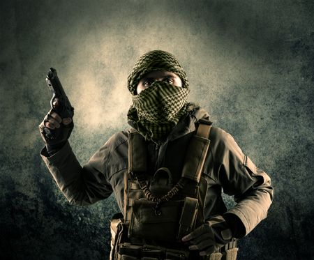 Portrait of a heavily armed masked soldier with grungy background concept