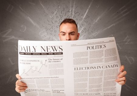 Young smart businessman reading daily newspaper with alphabet letters above his head