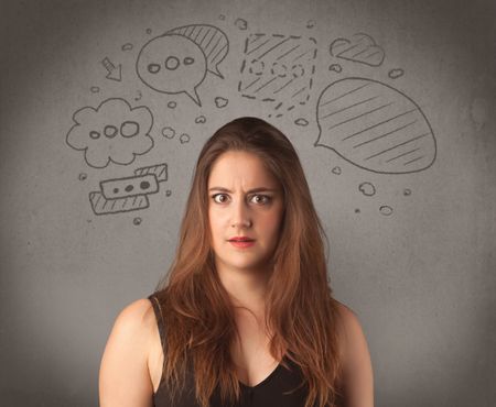 cute-female-student-making-funny-expressions-630808400 A cute female student making funny expressions with thoughts in her head illustrated by drawn chat bubbles on the urban wall background concept.