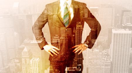 Business man looking at warm overlay city background