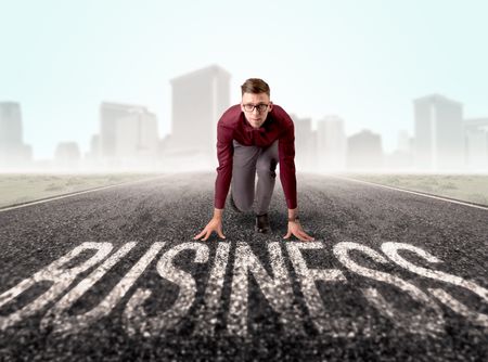 Young determined businessman kneeling before business text 