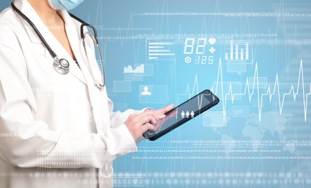 Female doctor holding tablet with blue background and heart related charts 