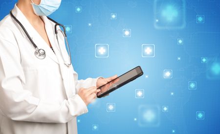Female doctor holding tablet with blue background and crosses