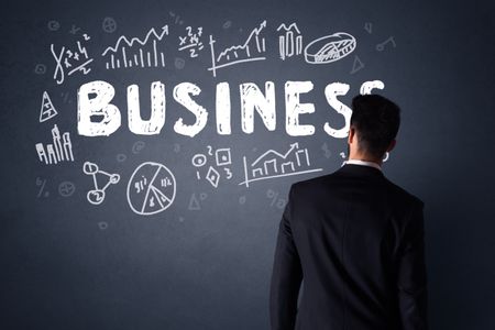 young-businessman-black-suit-standing-front-631555400 Young businessman in black suit standing in front of a detailed business plan