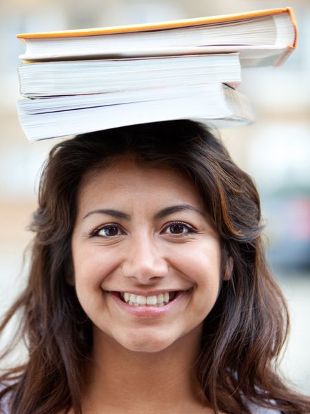 Female student balancing books on top of her head