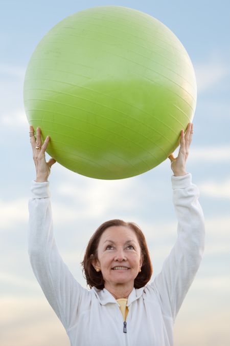 Beautiful woman portrait outdoors holding a pilates ball
