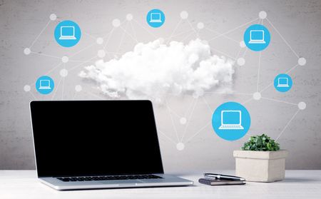 office-desk-laptop-flower-coffee-mobile-635164400 An office desk with laptop, flower, coffee, mobile phone and illustration in the background of connected computers around big white cloud