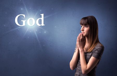 Young woman praying on a blue background with the word God written above her