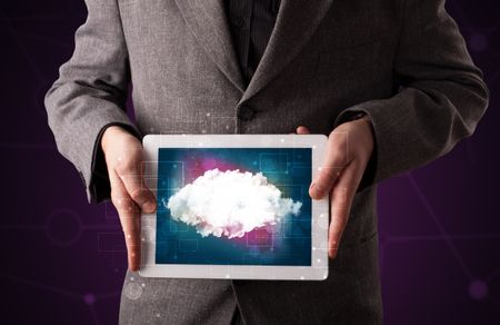 Casual businessman holding tablet with cloud icon and purple background