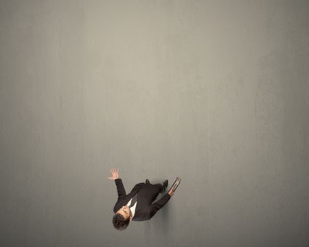 Young businessman contemplating a decision standing on a grey surface