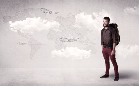 Handsome young man standing with a backpack on his back and planes in front of a world map as a background