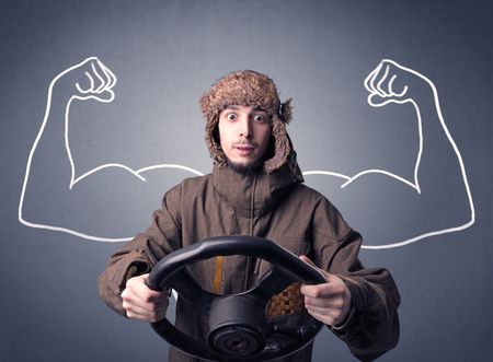 Young man holding black steering wheel with muscly arms drawn next to him