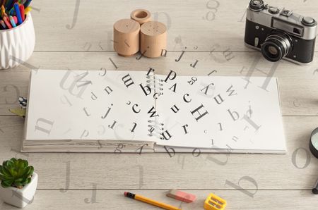 Open notebook on the floor with office instruments nearby and letters on it