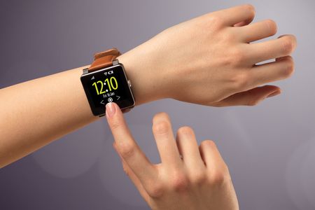 Naked female hand with smart wristwatch and digital clock on the screen 