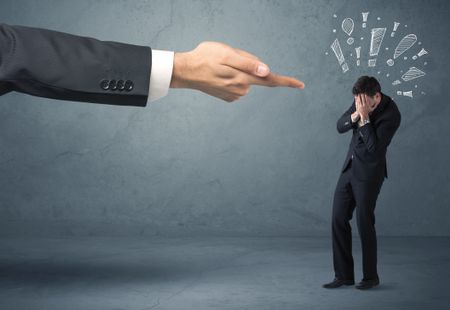 Employee in trouble getting last warning from boss concept with big business hand pointing at salesman and drawn exclamation marks