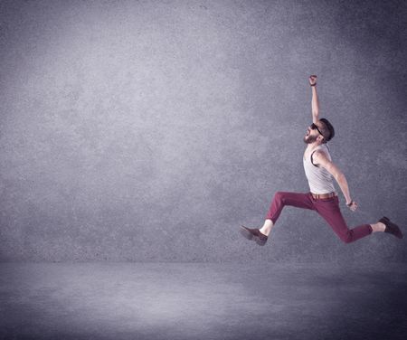 A hipster guy in stylish clothes shouting in front of an empty urban concrete wall background concept