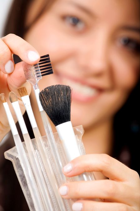 girl holding make up brushes - focus is on the brushes