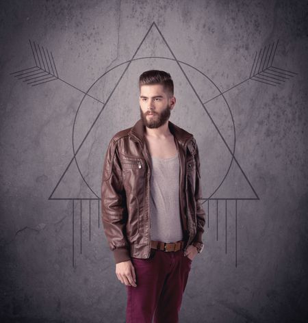 A young hipster male in modern clothes standing in front of an urban wall with modern sign illustration concept