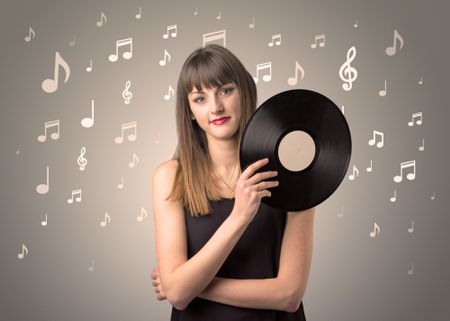 Young lady holding vinyl record on a brown background with musical notes behind her