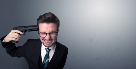 Young lost businessman man shooting his head with gun