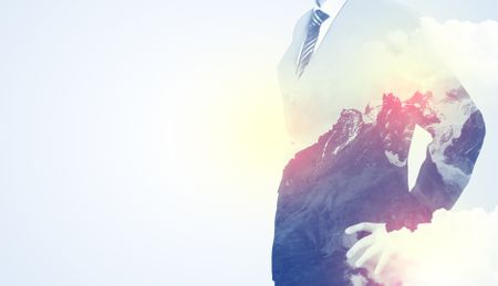 Businessman standing and thinking with snowy mountain graphic