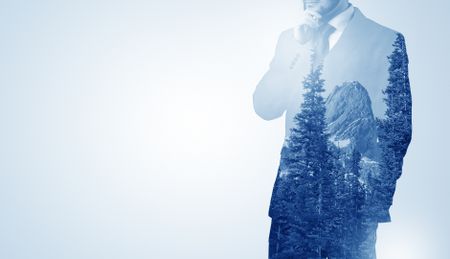 Young businessman standing and meditate with trees on the background 