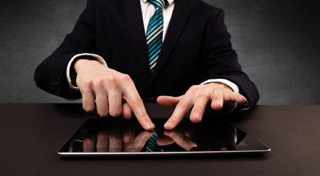 Businessman in suit typing with dark background