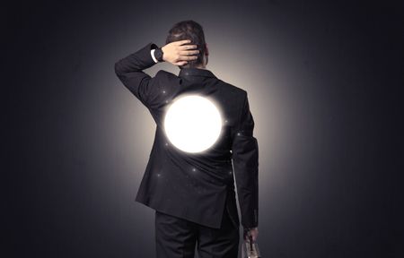 Businessman standing and thinking with maze graphic on his back