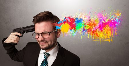 Man shoots his head with gun and colorful splotch are coming out from his head