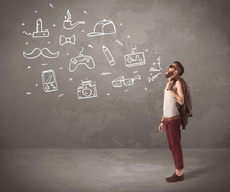 A funny hipster person in casual urban clothing shouting drawn everyday items like camera, tie or pen on city wall concept