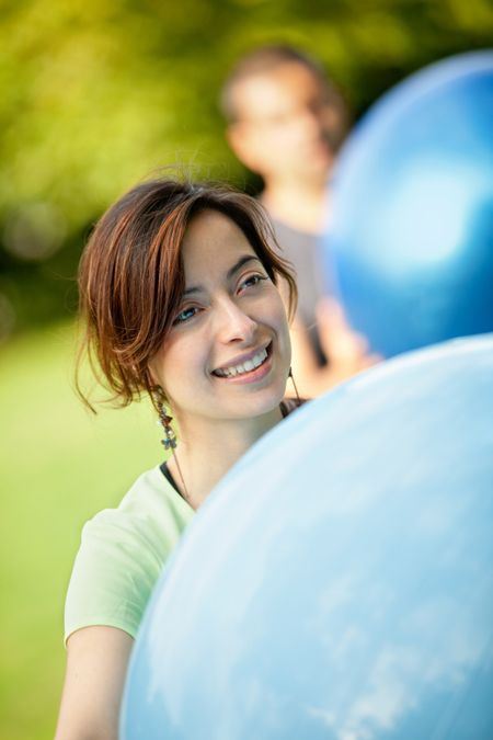 Beautiful woman portrait smiling holding a pilates ball outdoors