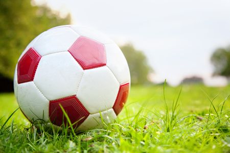 Image of a football lying over green grass outdoors