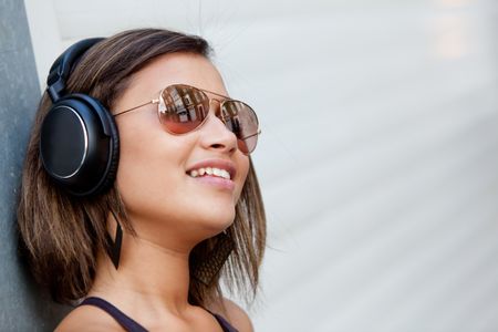 Beautiful woman with headphones and wearing sunglasses
