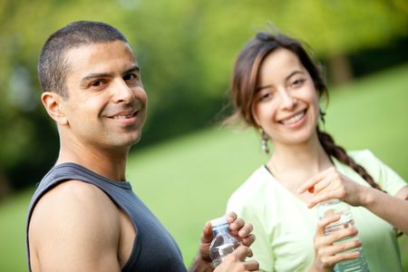 Athletic people holding bottles of water outdoors