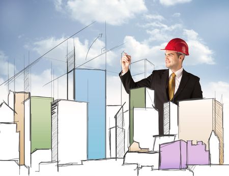 A young construction worker in a red safety helmet happily planning a city sight and drawing lines, arrows, angles, buildings with a pen in his hand