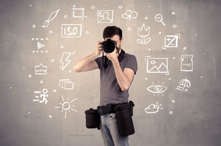 An amateur hobby photographer learning to use a professional digital camera with camera settings icons on the background wall concept