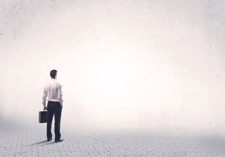 Serious business man standing on grey brick floor and thinging about decisions concept