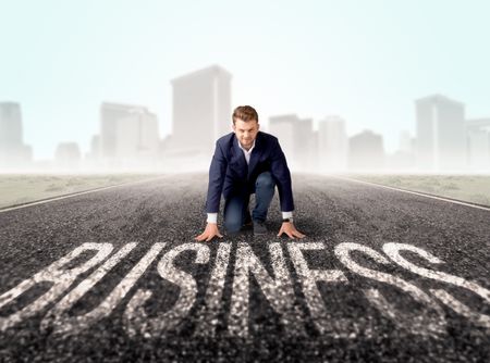 Young determined businessman kneeling before business text