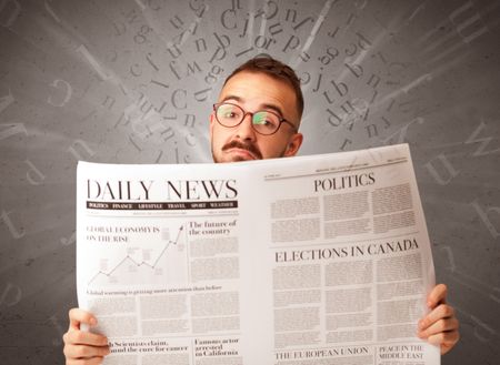 Young smart businessman reading daily newspaper with alphabet letters above his head