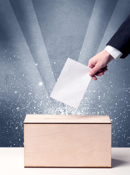 Ballot box with person casting vote on sparkling background