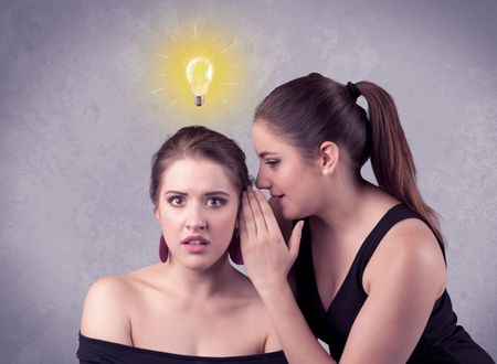 A young girl has an idea illustrated with a drawn glowing light bulb above the head, while a friend whispers a secret in her ear concept.