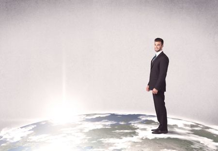 A young elegant office worker standing on top of a drawn world globe while celebrating his successful career concept.