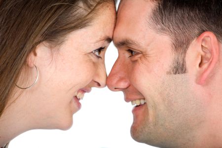 couple captured in a happy moment smiling and facing each other - isolated over a white background