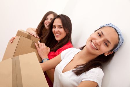 Group of girls with cardboard boxes moving to a new house