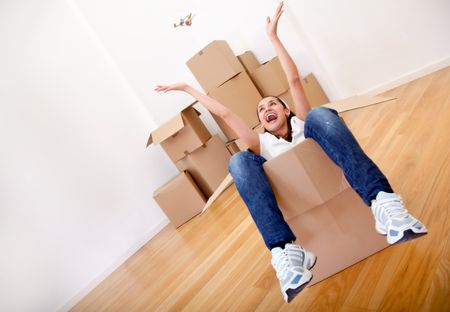 Woman sitting inside a cardboard box while packing