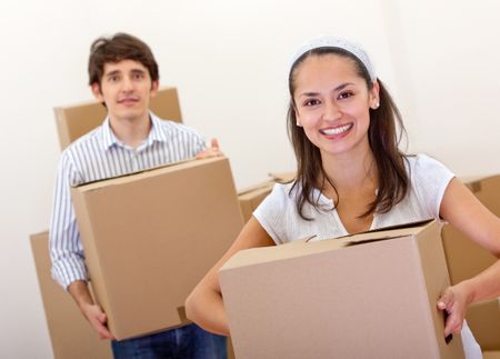 Couple with cardboard boxes moving to a new house