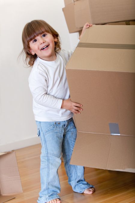 Kid playing with cardboard boxes excited about moving