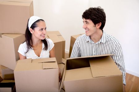  Couple with cardboard boxes moving into a new house